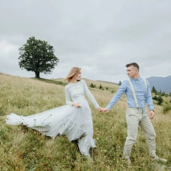 Pareja de recién casados caminando juntos en el campo en una sesión de boda al aire libre en Mallorca